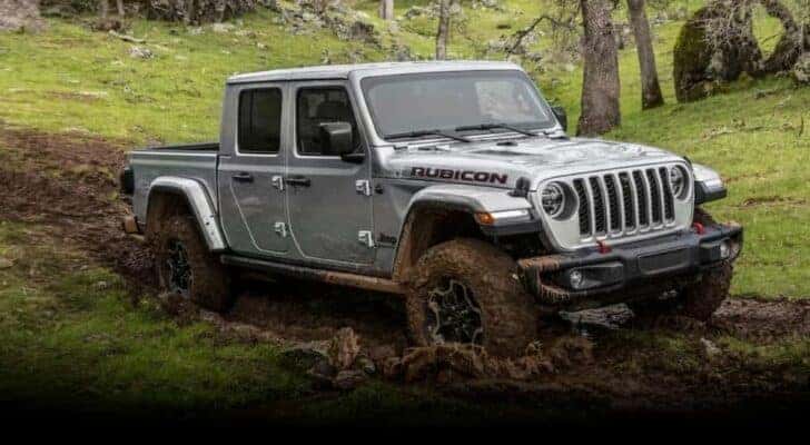 A silver 2023 Jeep Gladiator Rubicon is shown driving off-road after visiting Cincinnati truck sales.