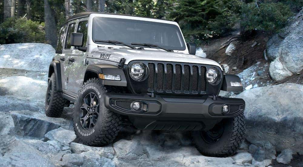A silver 2020 Jeep Wrangler Willys is shown from the front at an angle after leaving a dealer that has a used Jeep Wrangler for sale.