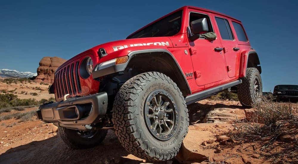 A red 2023 Jeep Wrangler is shown from the front at a low angle.