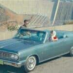 A blue 1964 Chevy Malibu Convertible is shown from the front at an angle.