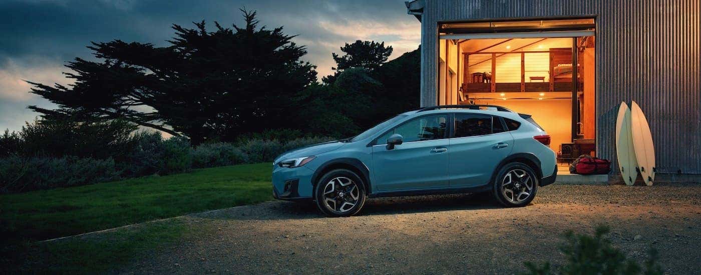 A blue 2018 Subaru Crosstrek Limited is shown parked near a house.