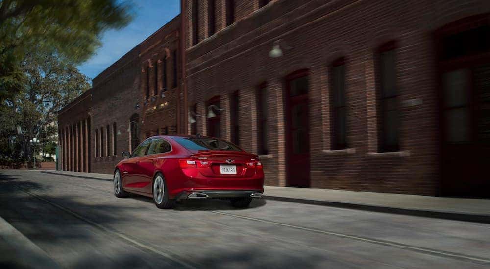 A red 2021 Chevy Malibu for sale is shown from the rear at an angle.