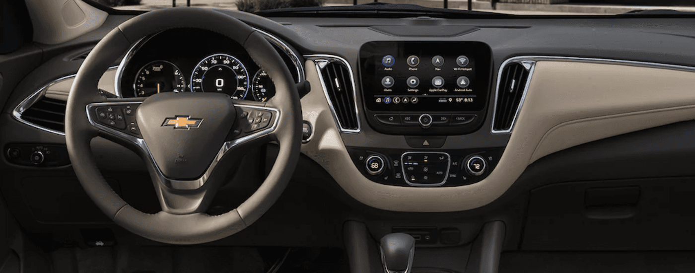The gray and tan interior and dash of a 2022 Chevy Malibu is shown.