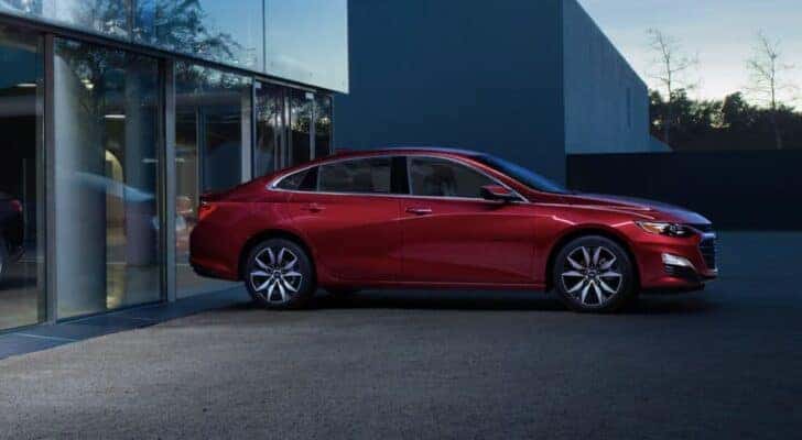 A red 2022 Chevy Malibu for sale is shown parked on a driveway.