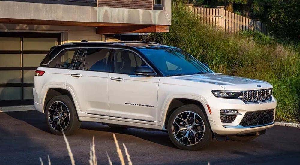 A white 2023 Jeep Grand Cherokee is shown from the front at an angle after browsing Dayton SUV sales.