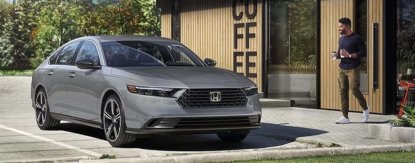 A gray 2023 Honda Accord is shown parked near a coffee shop.