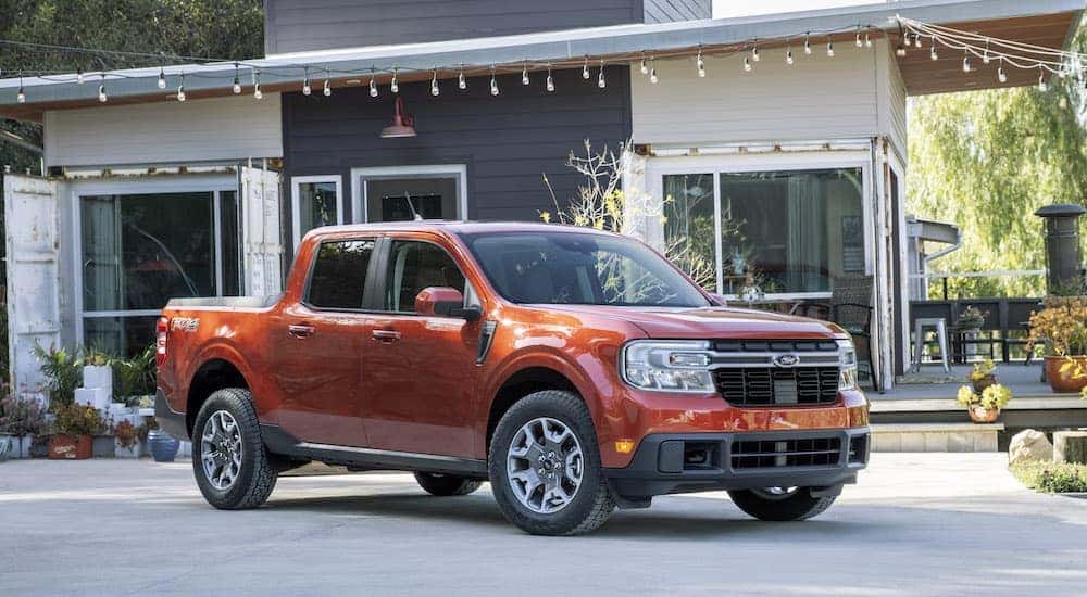 An orange 2021 Ford Maverick Lariat is shown from the front at an angle.