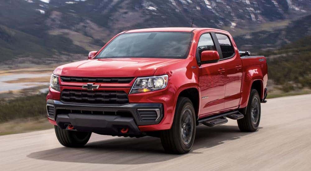 A red 2022 Chevy Colorado is shown driving on a dirt road.