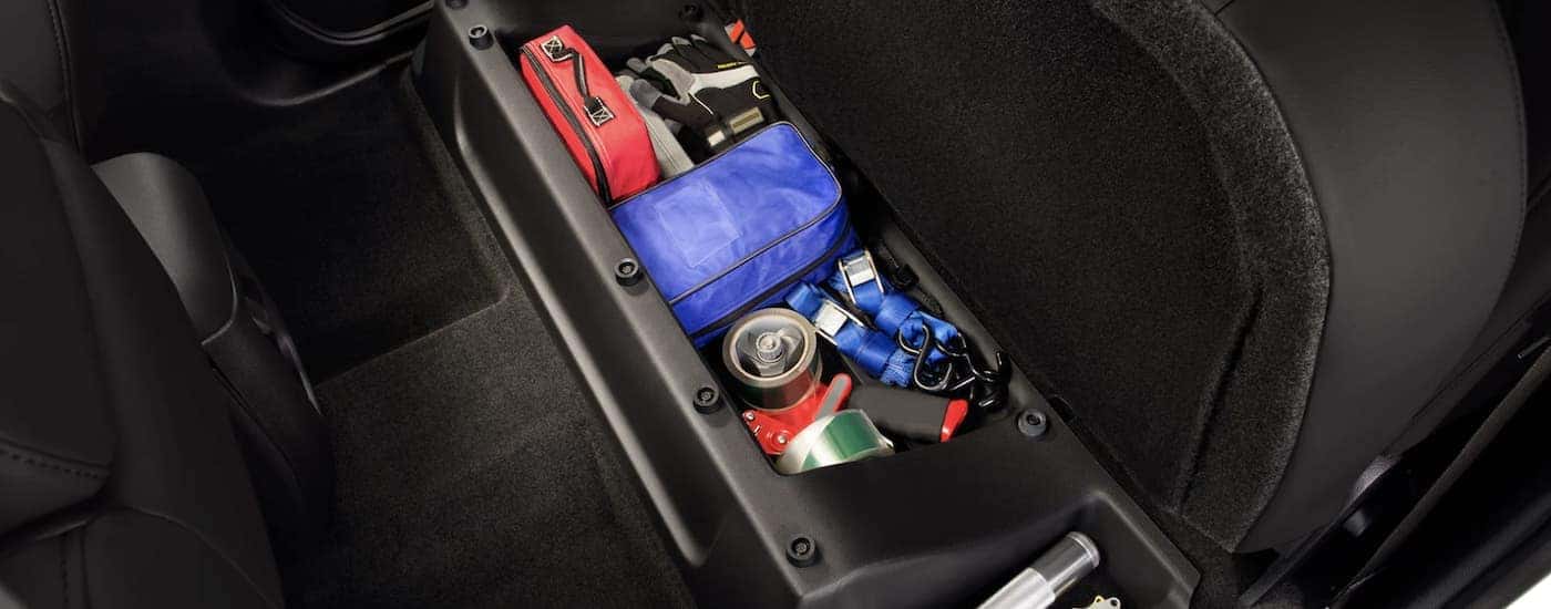 A set of items are shown sitting in the storage compartment of a 2022 Chevy Colorado Z71.