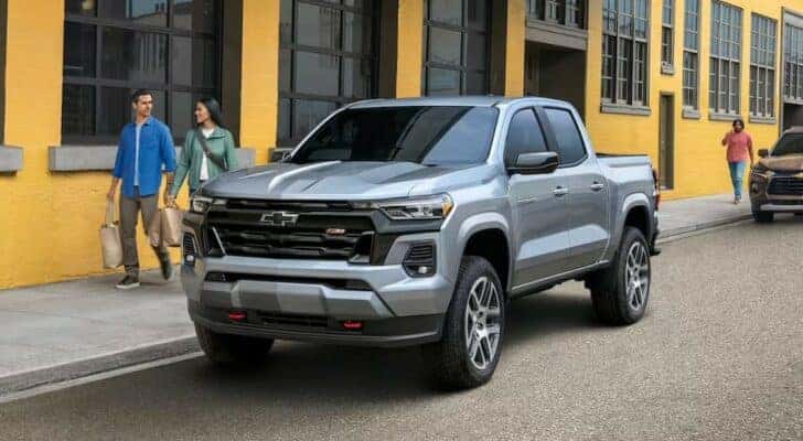 A silver 2023 Chevy Colorado is shown parked near a city curb after viewing a Used Chevy Colorado for sale.