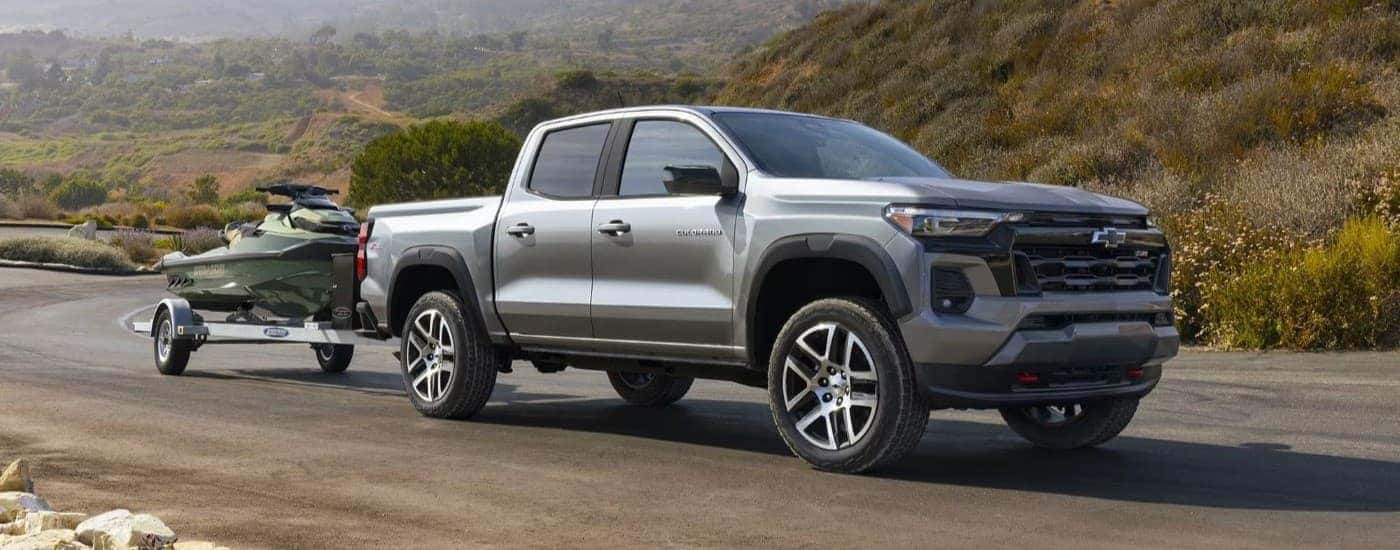 A silver 2023 Chevy Colorado Z71 is shown towing a jetski.