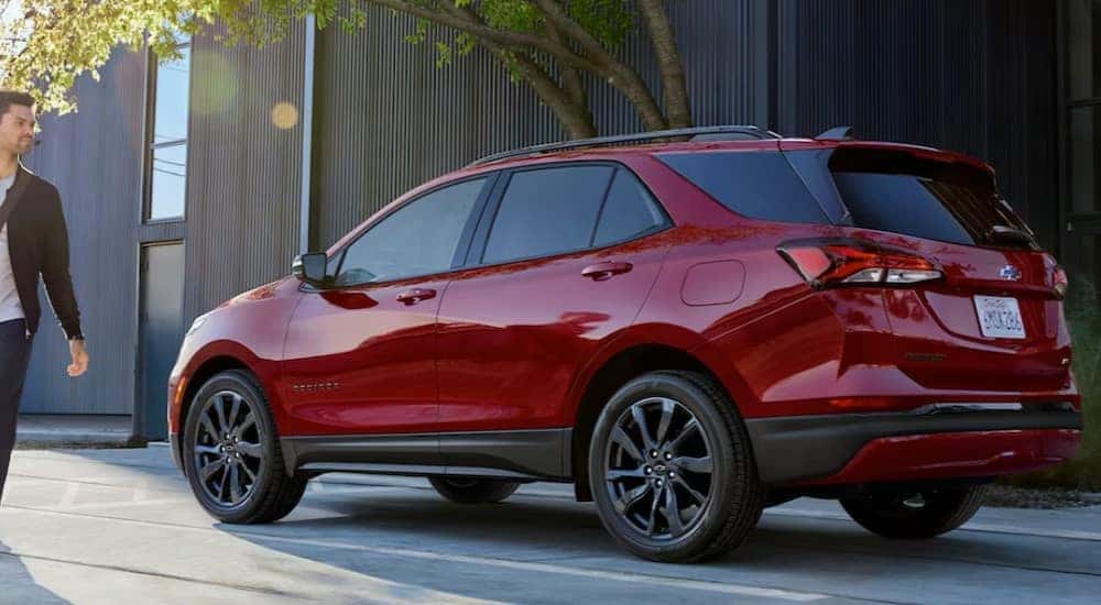 A red 2024 Chevy Equinox RS is shown parked near a building.