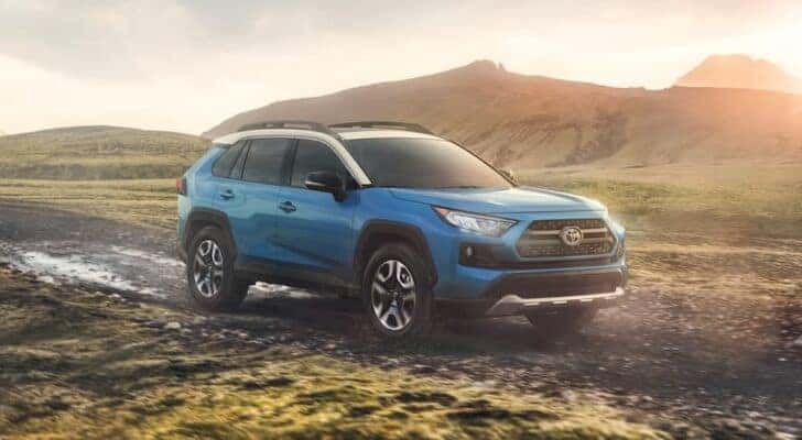 A blue 2020 Toyota RAV4 is shown driving off-road.