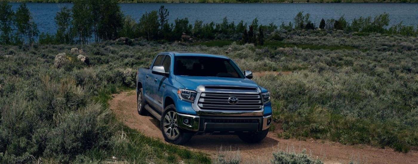 A blue 2020 Toyota Tundra is shown driving on a trail.