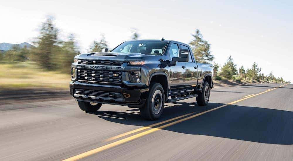 A black 2020 Chevy Silverado 2500 HD is shown driving.