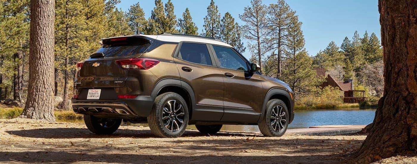 A brown 2021 Chevy Trailblazer is shown from behind while parked in a forest.
