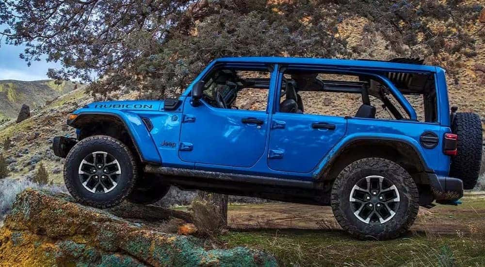 A blue 2024 Jeep Wrangler Rubicon is shown parked near a cliff.