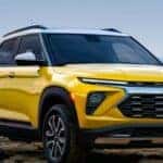 A yellow 2024 Chevy Trailblazer for sale is shown parked near water.