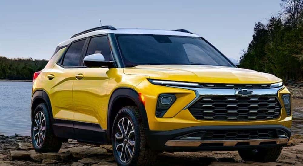 A yellow 2024 Chevy Trailblazer for sale is shown parked near water.