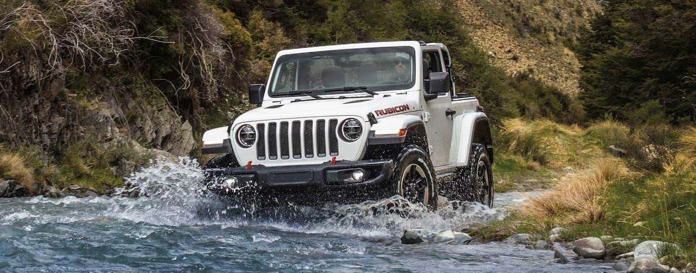 A white 2021 Jeep Wrangler Rubicon is shown fording a river.