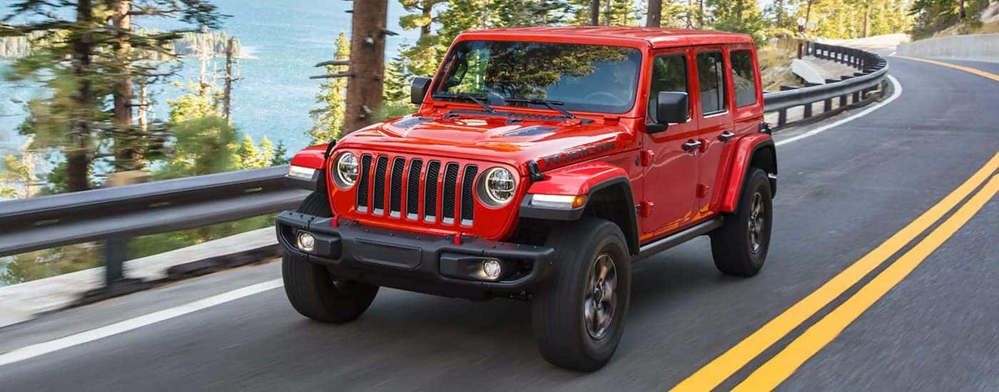 A red 2021 Jeep Wrangler Rubicon Unlimited is shown driving.