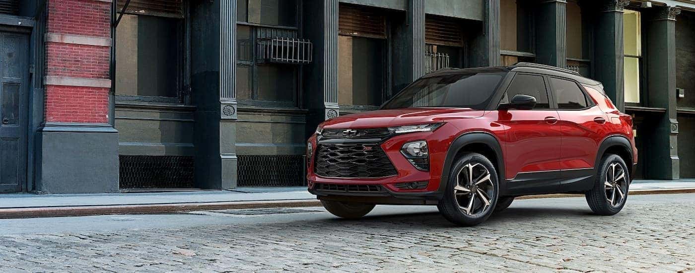 A red 2021 Chevy Trailblazer RS angled left and driving down a city street.