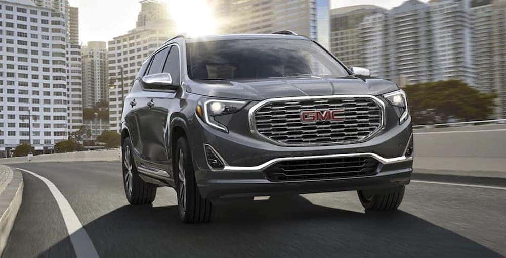A grey 2020 GMC Terrain Denali driving from a dealer with a 2020 GMC Terrain for sale.