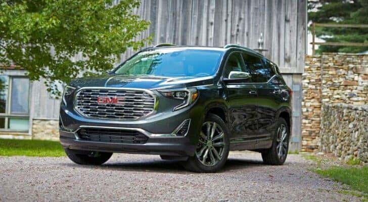 A black 2020 GMC Terrain Denali parked outside a barn.