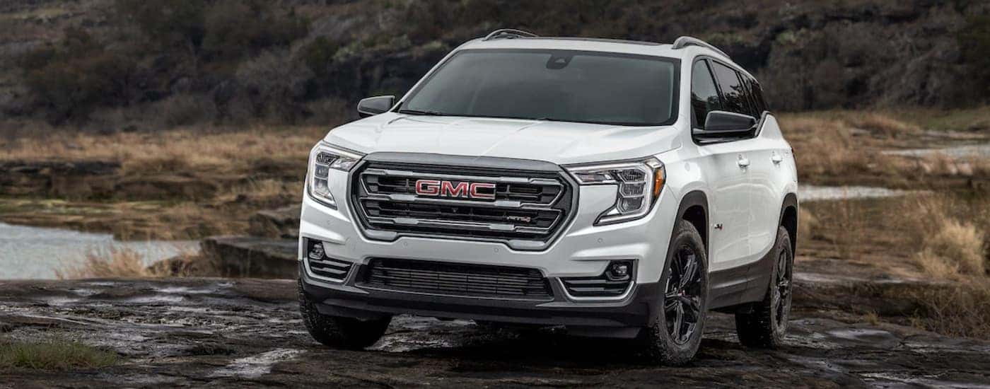 A white 2022 GMC Terrain off-roading through mud.