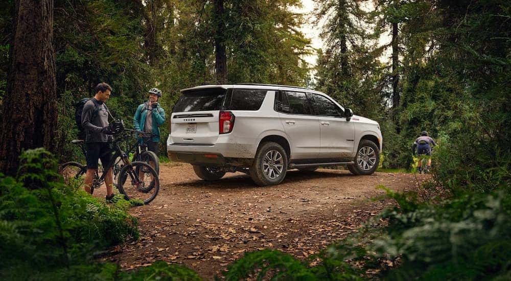 A white 2022 Chevy Tahoe Z71 is shown parked near people on bikes.