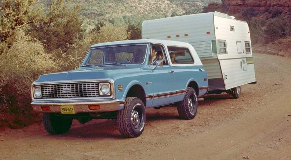 A blue 1969 Chevy K-5 Blazer is shown towing a trailer.
