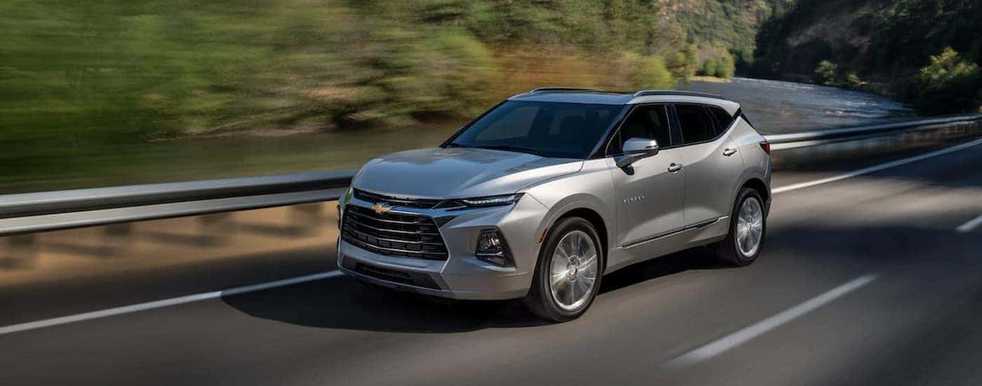 A silver 2021 Chevy Blazer for sale is shown driving on a highway.