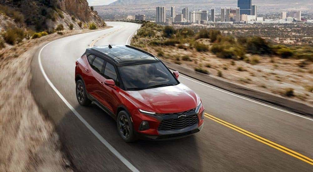 Overhead view of a red 2021 Chevy Blazer RS driving away from a city.