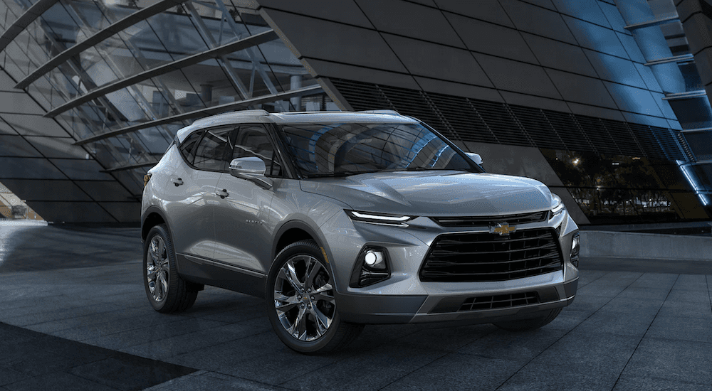 A silver 2021 Chevy Blazer parked near a modern building.