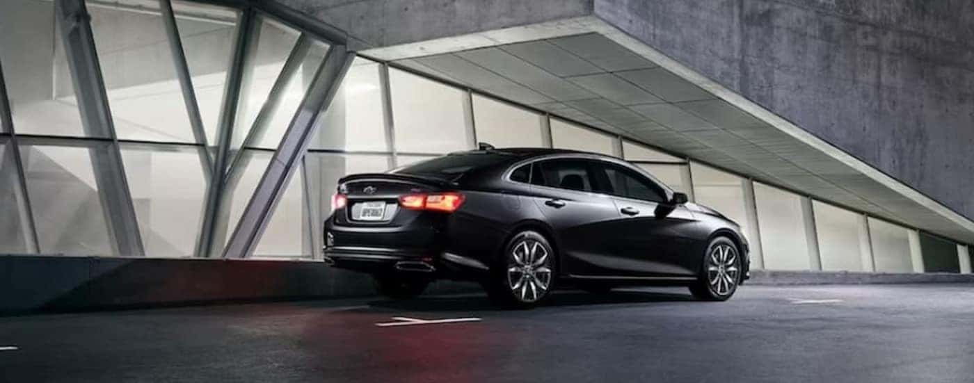 A black 2024 Chevy Malibu Midnight Edition is shown parked on a parking spot.
