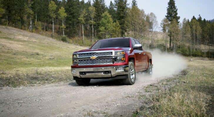 A red 2014 Chevy Silverado 1500 LTZ is shown driving off-road after viewing a used Chevy Silverado for sale.