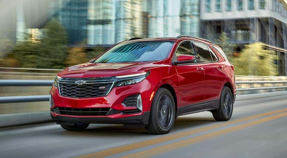A red 2022 Chevy Equinox RS is shown driving on a bridge.