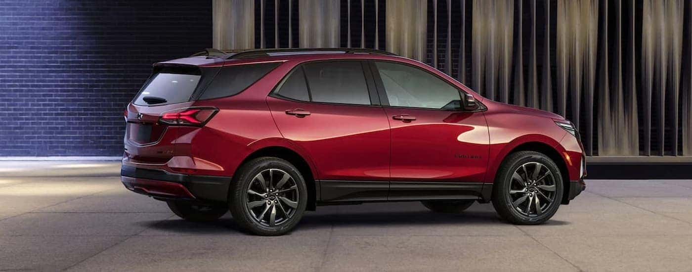 A red 2022 Chevy Equinox RS is shown parked near a brick wall.