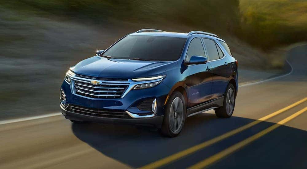 A blue 2022 Chevy Equinox is shown driving on a highway after viewing a used Chevy Equinox for sale.