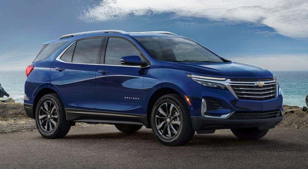 A blue 2022 Chevy Equinox for sale parked near the ocean.