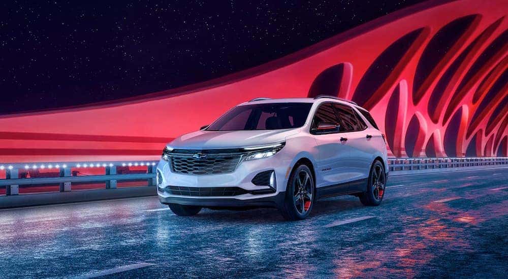 A white 2022 Chevy Equinox Premier Redline Edition driving over a bridge.
