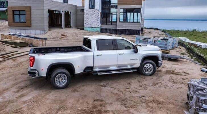 A white 2024 Chevy Silverado 3500 is shown parked on a construction site.