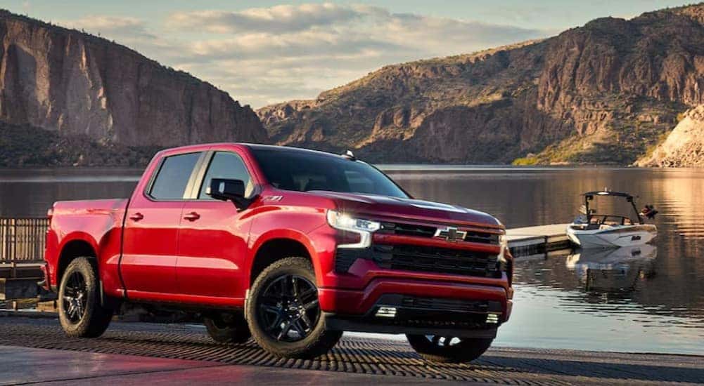 A red 2024 Chevy Silverado 1500 RST is shown parked near a lake after viewing a Chevy Silverado 1500 for sale in Dallas.