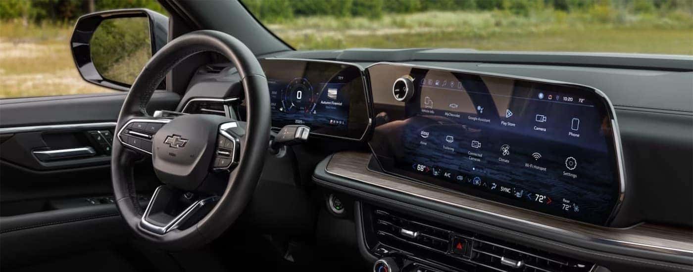 A black steering wheel and dashboard in the interior of a 2025 Chevy Tahoe.