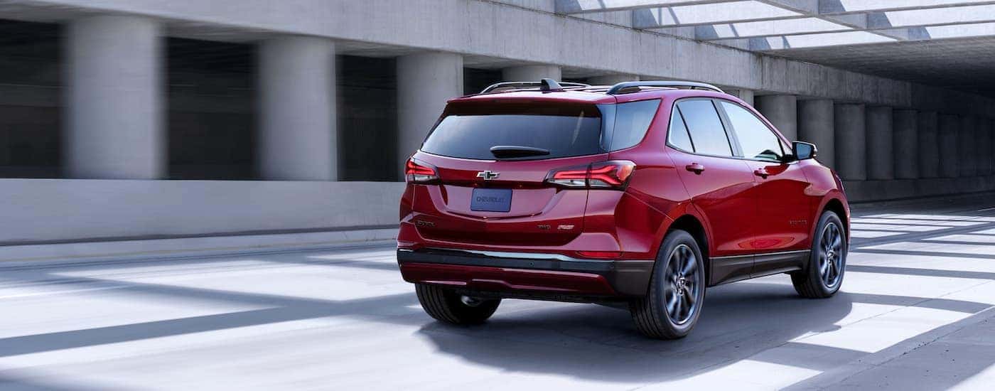 A red 2024 Chevy Equinox RS is shown from the rear at an angle.