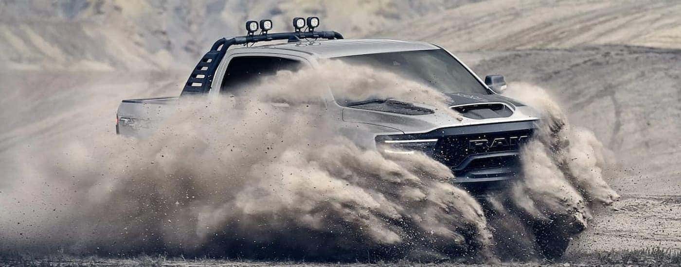 A silver 2022 Ram 1500 TRX is shown driving off-road.