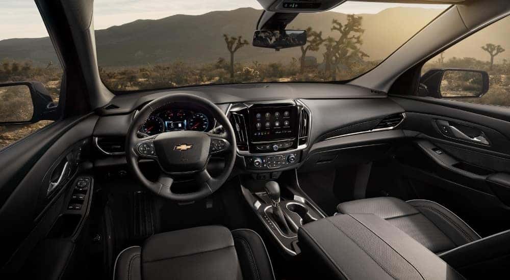 The black interior of a 2021 Chevy Traverse for sale is shown from the driver's seat.
