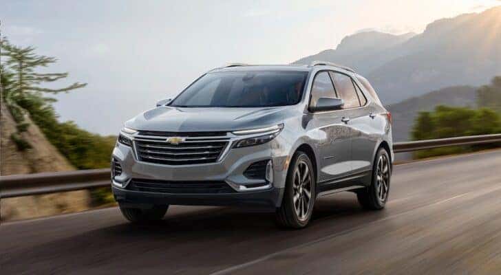 A grey 2024 Chevy Equinox driving and angled left.