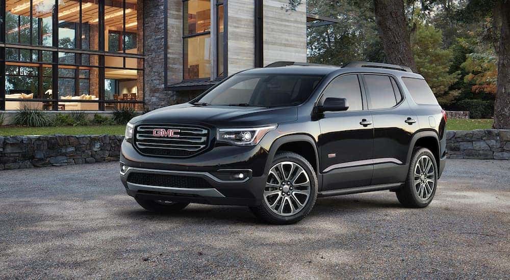A black 2019 GMC Acadia for sale parked outside a building.