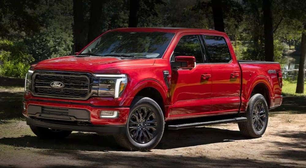 A red 2024 Ford F-150 is shown parked off-road.
